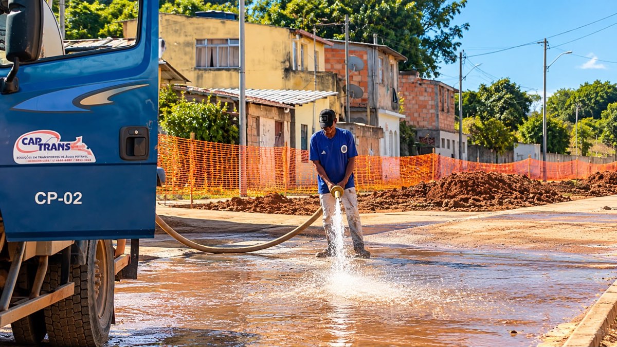 Funcionário da Captrans lavando uma rua com a mangueira do caminhão-pipa CP-02